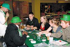 Students anticipate the dealers next move of the cards during an intense game of Black Jack.
