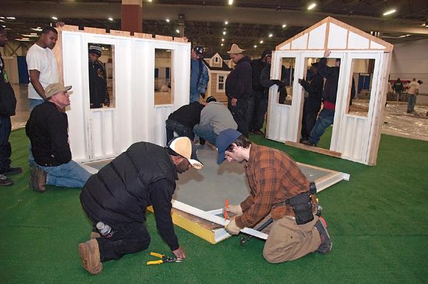 Domonic Fortune (L) and Aaron Ries, both in the foreground, assisted with the final prep work on the small home displayed by Carpentry majors at the recent NARI Home Improvement Show. 