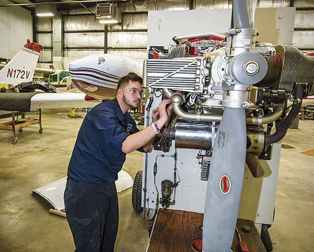 Oscar Santiago, student at the Aviation center working on a prop engine.