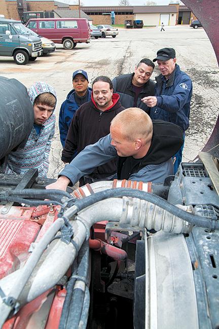 Instructor Dan Zdrojewski shows students (from left to right) Jesse Roberts, Margaret Malcom, Edwin Garcia, Jonas Bustillos, and instructor Rick Eaton different aspects of the engine. 