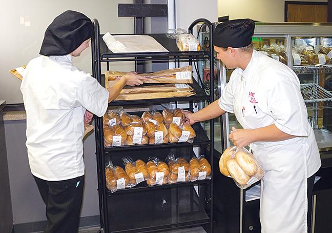 Tabitha Komoski and Crystal Miller, Baking and Pastry program students, put out bread items for students to purchase throughout the day. 