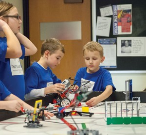 Madison Master Builders’ members carefully positioning their robot on the grid in the Robot Room.