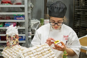 Rebecca Frazier, Baking and Pastry Arts program, attaches colored gelatin to a ginger cookie frame to make the windows for her and Octavia Lewis' gingerbread house for the competition.