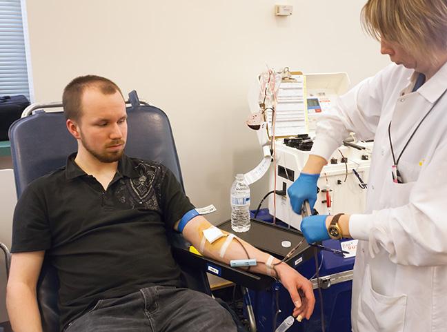 Computer Electronics Technology student Joe Knapp (L) makes his donation to the 2015 Blood Drive, as Donor Specialist Hanna Kashpar looks on. 
