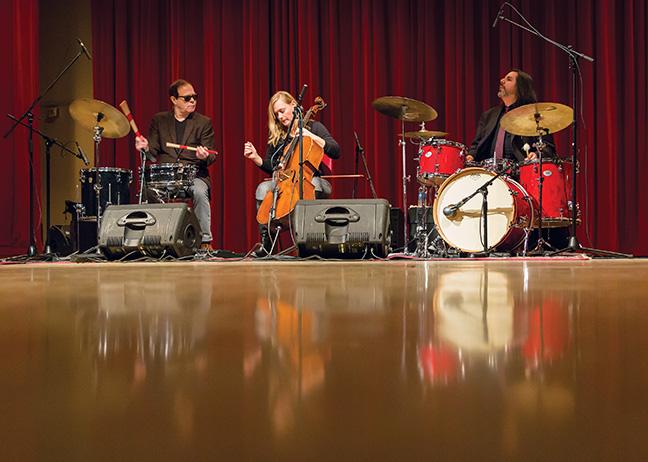 In the C-Building Auditorium on Feb. 20, the band Nineteen Thirteen plays the song  “Mr. Panicker,” while Victor DeLorenzo plays the drums and percussion instruments (left), with Janet Schiff on the cello, and Greg Lopez on the other drums (right). 