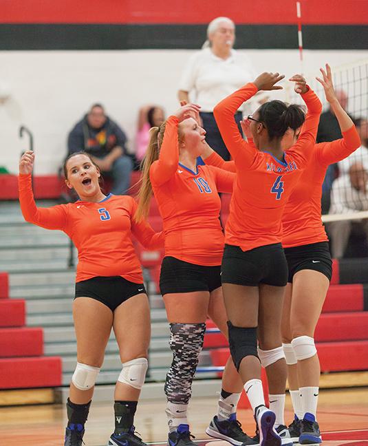 Teammates Haley Derks (5), Kayla Bockhop (10), Niesha Wigley (4), and Ashley Oldenburg (6) celebrate another great play during their matchup against Malcolm X College on Oct. 13. Stormers won in three sets. 