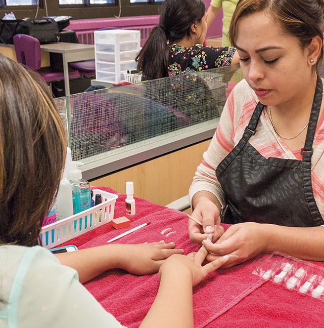 MATC nail technician students, (from left to right) Myat Mon and Jessica Ramos team up as Ramos applies acrylic nails designs onto her colleague.