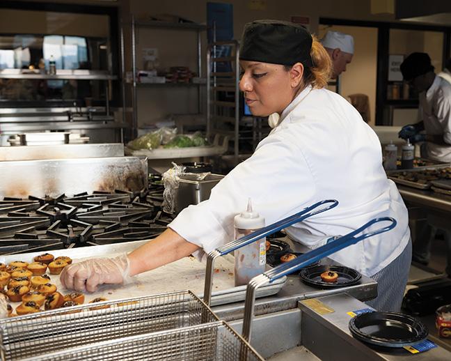 Malina Schweinert, Culinary Management program, prepares a dish for the French station.