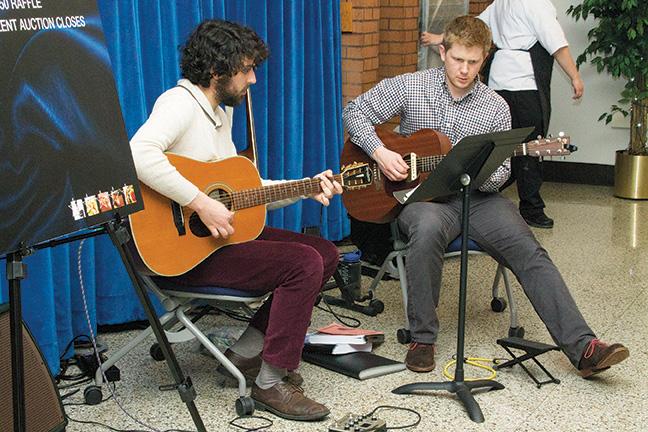 Music Occupations program students Andrew Koenig (R) and Eric Fricke entertain guests with acoustic music during the Five Star fundraiser event.