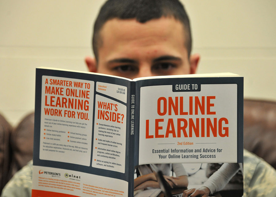 Senior Airman Kyle Struecker, 69th Maintenance Squadron crew chief, reads a book on online learning  at the Education Center on Grand Forks Air Force Base, N.D., March 31, 2015. Stuecker has taken two college level examination program exams and has two more classes left before starting his clincals to receive an associate’s degree in applied science radiologic technology. (U.S. Air Force photo by Senior Airman Xavier Navarro/released)
