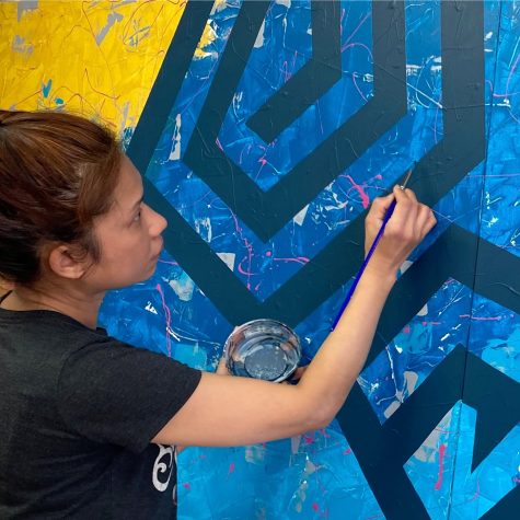 Byada working in the studio on her mural titled, Just Find Yourself and be Yourself