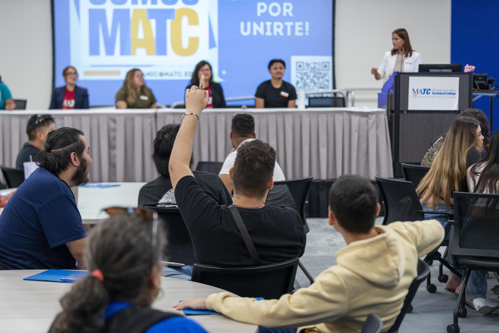 Estudiantes y sus padres hacen preguntas durante una orientación estudiantil/Students and their parents ask questions during a student orientation.
