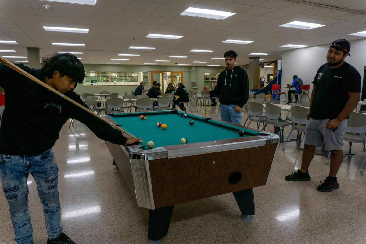  Students playing a round of pool in the Cyber Cafe at the Oak Creek campus on a Monday in September
