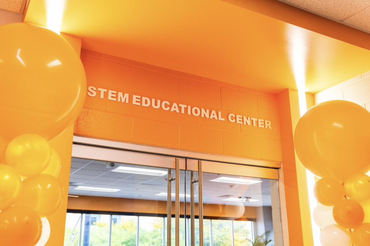 Bright, orange balloons form an archway over the entrance to the STEM Educational Center in the C-Building at the Downtown Campus.