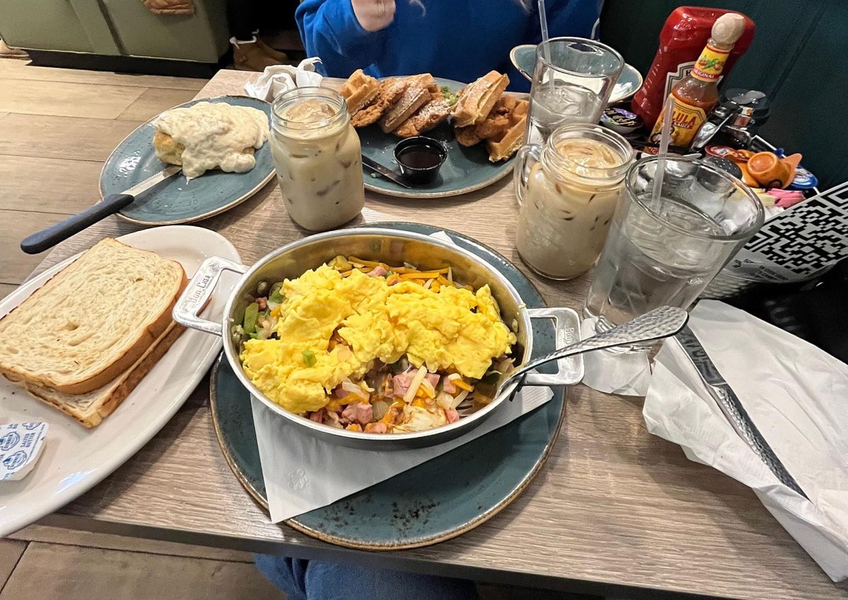 Two people sit at a booth with big breakfast plates. One person has only eaten a little bit of her food. Photo courtesy of student photographer GKV.