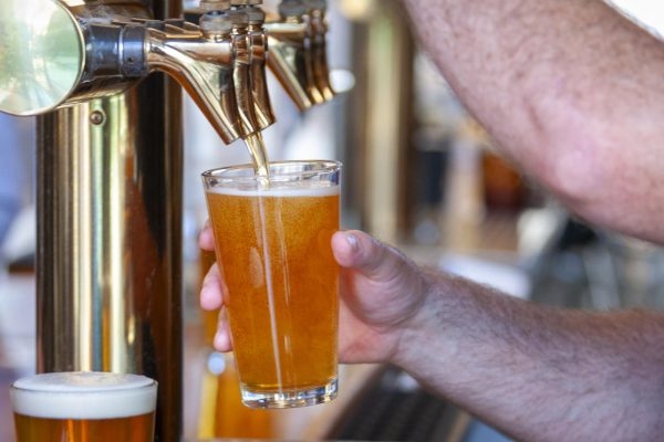 A bartender pours a beer from a tap.  Alcohol is the most used substance in America, according to the CDC.