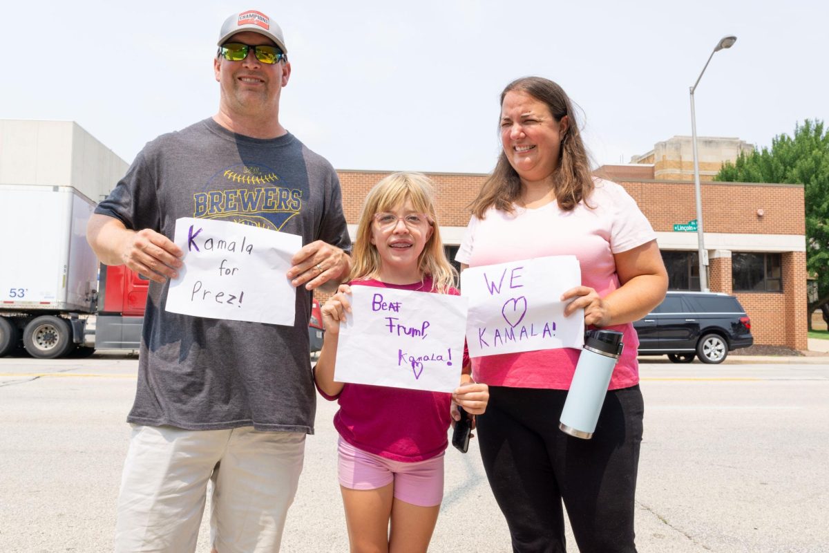 A family holds their signs in support of Vice President Kamala Harris, the presumptive presidential nominee for Democratic Party.