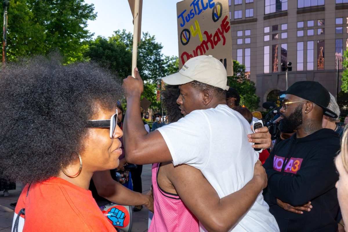 A protestor hugs the brother of D’Vontaye Mitchell who was killed on June 30, outside the Hyatt Hotel after being held down and restrained by security guards. 