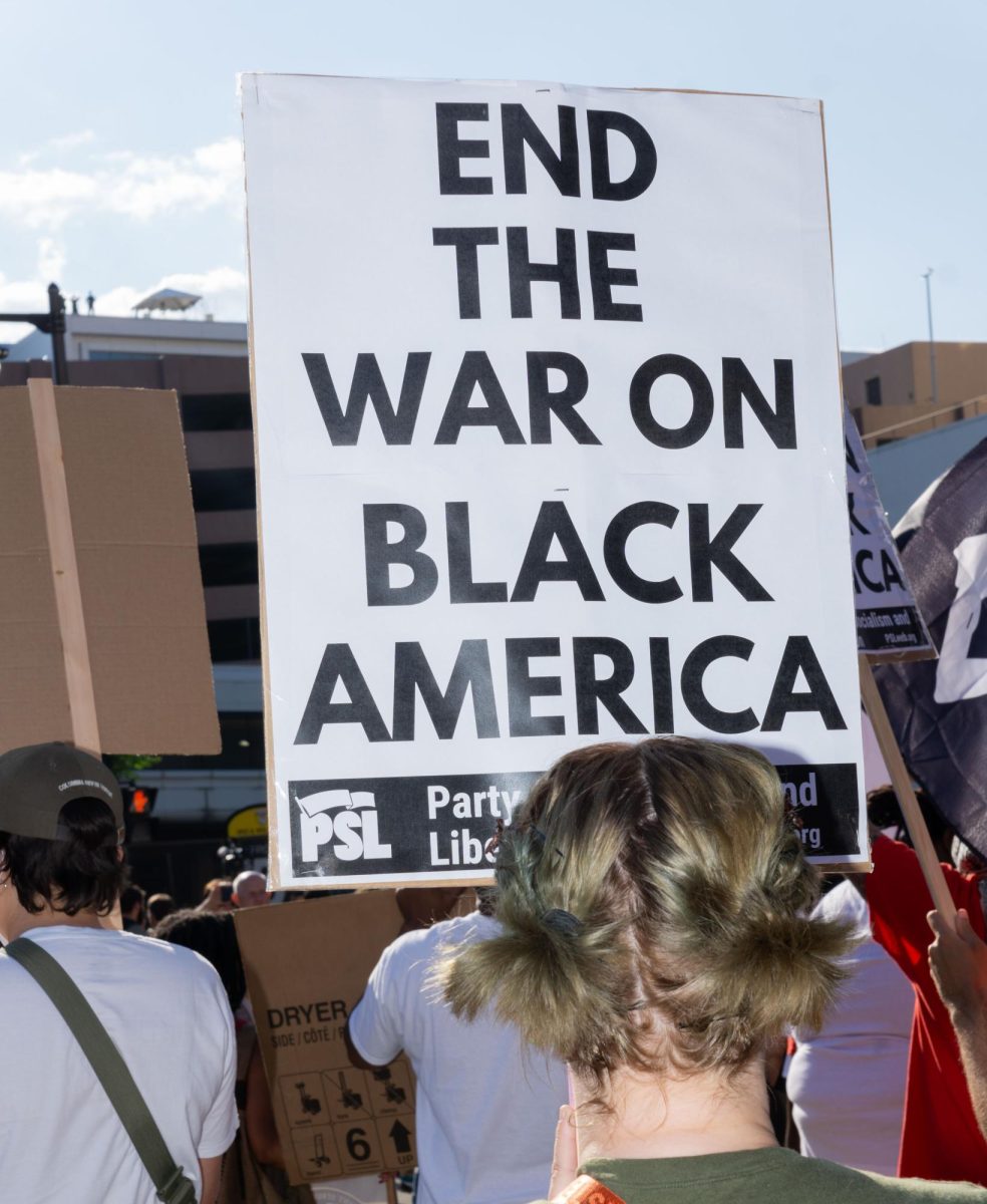 A protestor with a sign that reads "End war on Black America" in Milwaukee during the RNC.