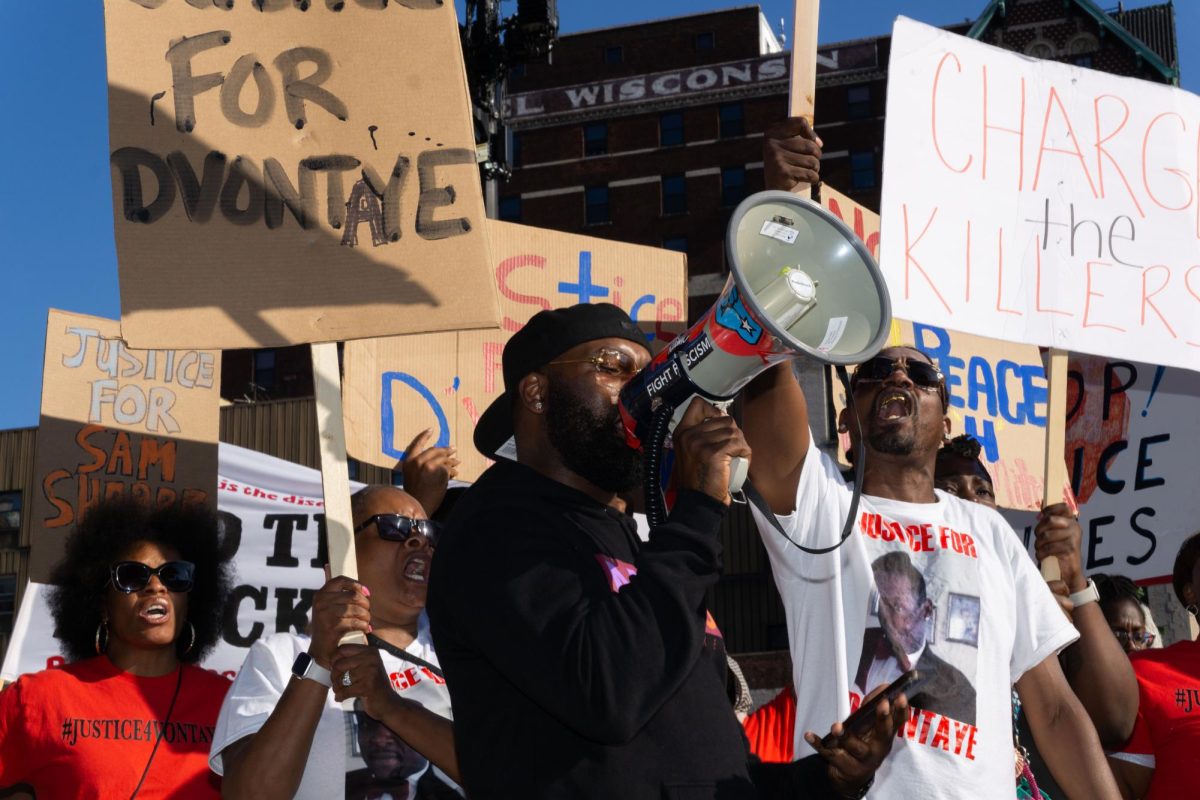 A cousin of D’Vontaye Mitchell shouts in the microphone "Say his name!  D’Vontaye Mitchell!" at a protest during the RNC in Milwaukee.