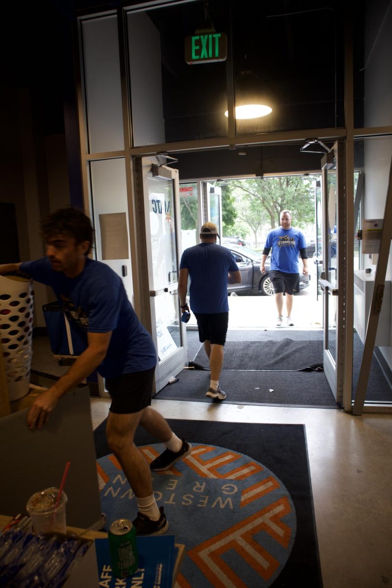 Students moving boxes through the entrance of Westown Green on move-in day