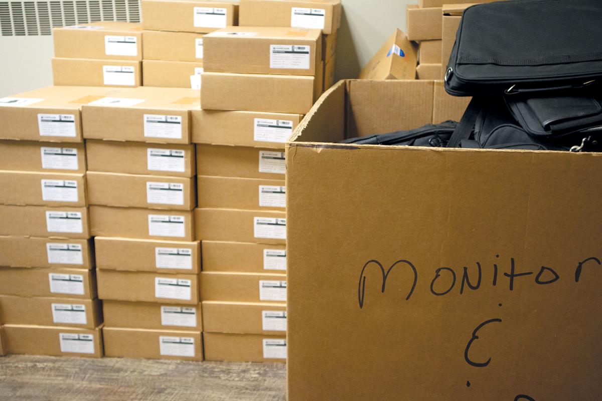 Laptops are boxed up and stacked in the FASTFund Office in Founders Hall.