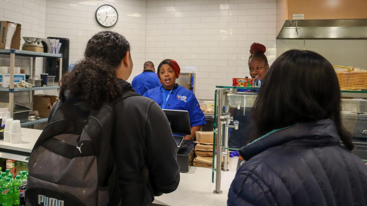 Culinary Assistant Mahogany Malone (l) checks out students at the Downtown Cafeteria on October 10. Culinary Specialist Cheri Tucker (r) works beside her. Tucker recently received an associate’s degree from MATC’s Culinary Arts program.  