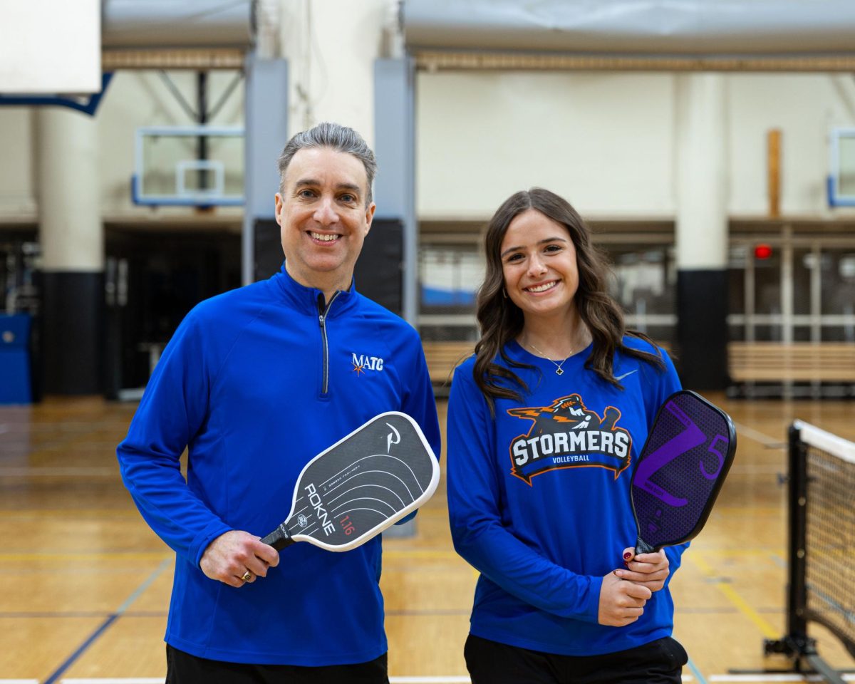 President Dr. Anthony Cruz and Teagan Cole, a freshman volleyball player, smiling after playing a game of pickleball at the new courts at the Downtown Campus gymnasium. 