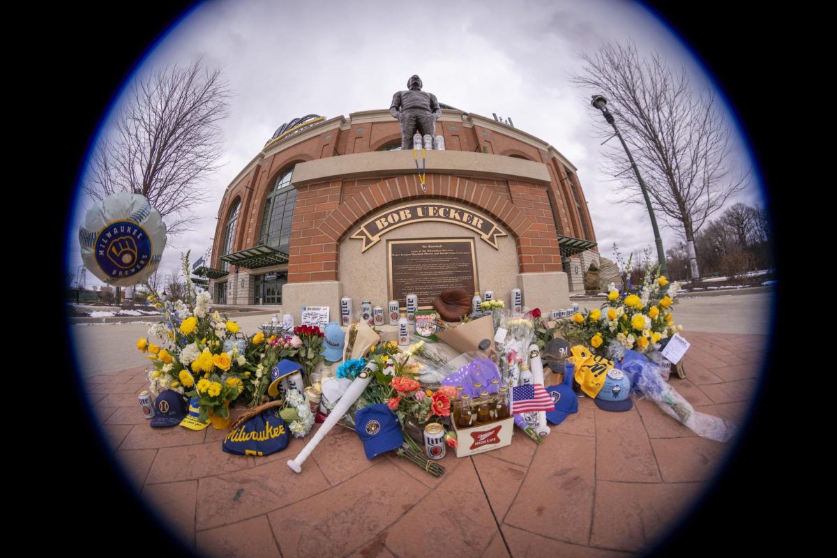 A Bob Uecker memorial is at the base of his statue at American Family Field where fans have placed flowers, baseball caps, beer and other items.