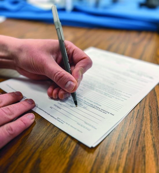 Elsa Marks signing her signature on the petition for name change 