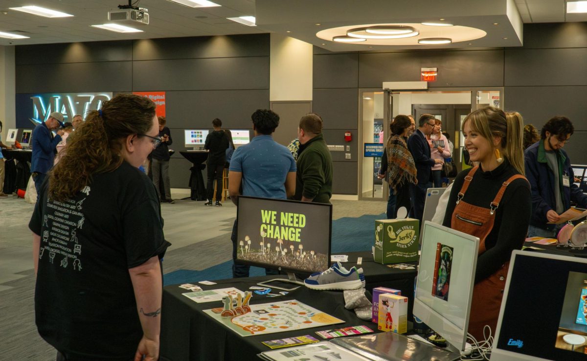 Graphic design students talked to guests about their designs at the Create the Spark portfolio night on May 8 2025. 