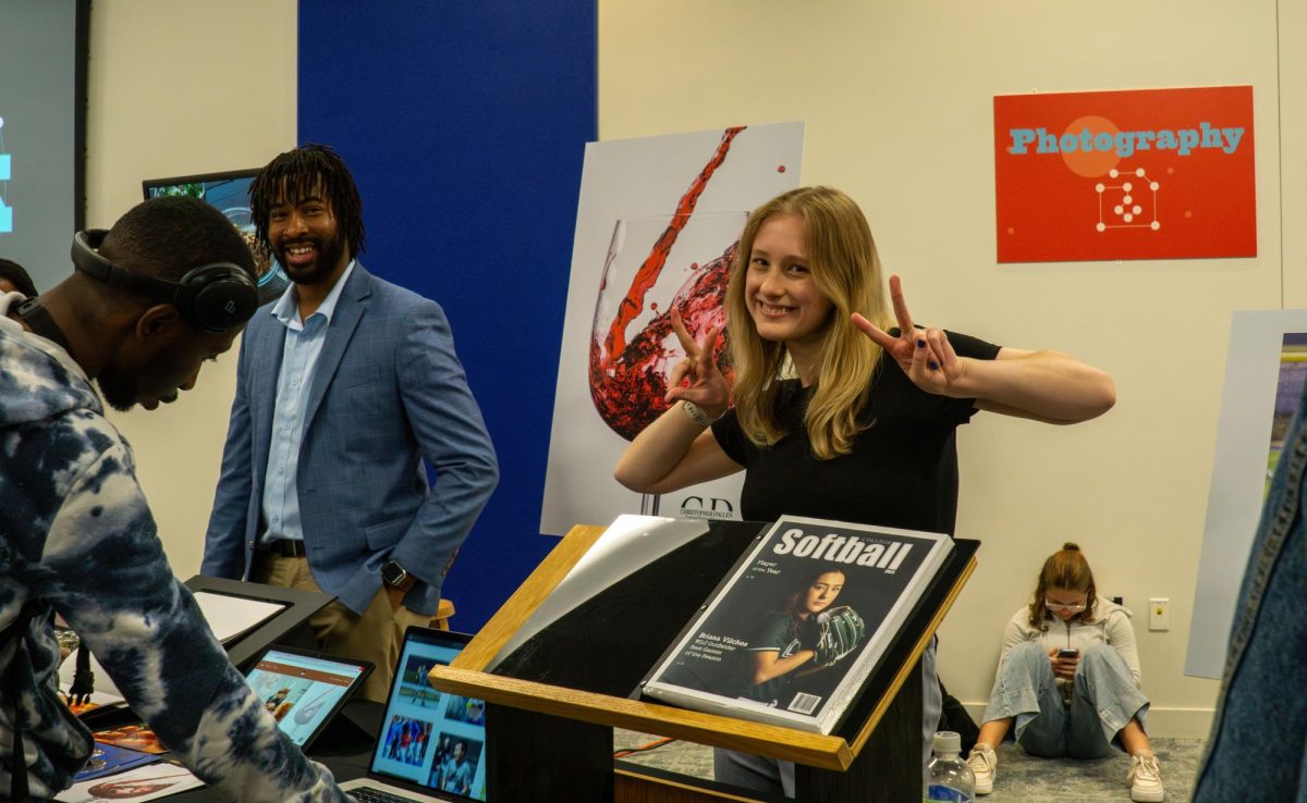 (pictured from left to right) Photography students, Christopher D’Allen Davis and Elizabeth Chapman pose for a picture at the Create the Spark portfolio night, May 8, 2025. 