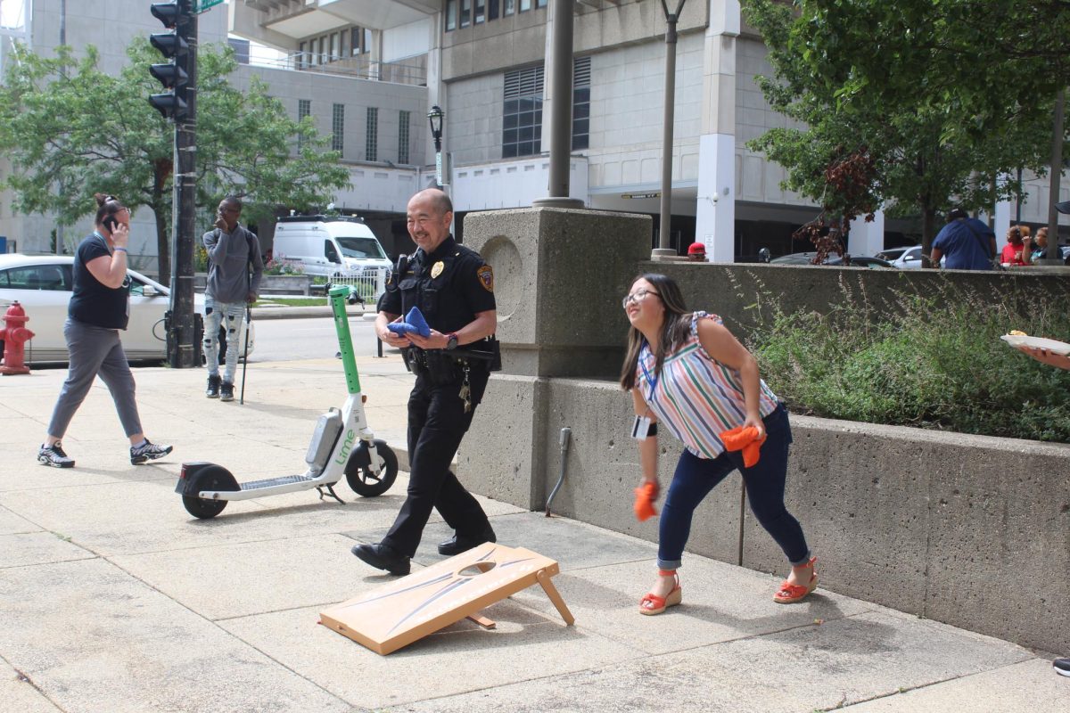 Two MATC staffers play corn hole at a Welcome Back event for students. Pictured left to right: Gary Morimoto, manager, Department of Public Safety; Maiyer Thao, student services specialist.