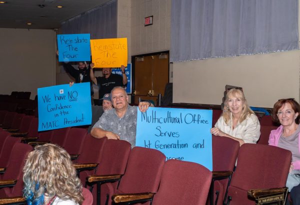 During an MATC District Board meeting, members of the MATC community hold signs in silent protest of the elimination of the Multicultural Services office and in support of the four staff members who were terminated.
