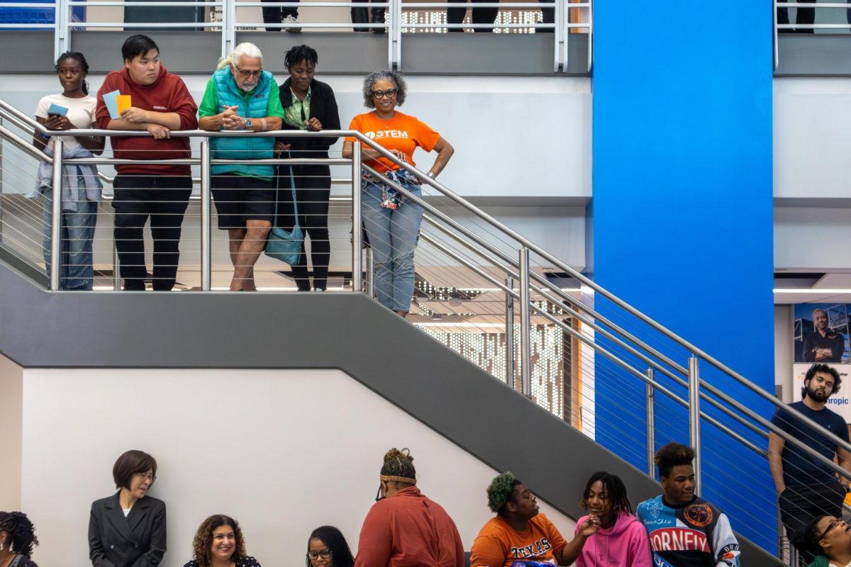 People lined a staircase and the second floor of the S Building to watch students model what to wear and not to wear at a career fair.