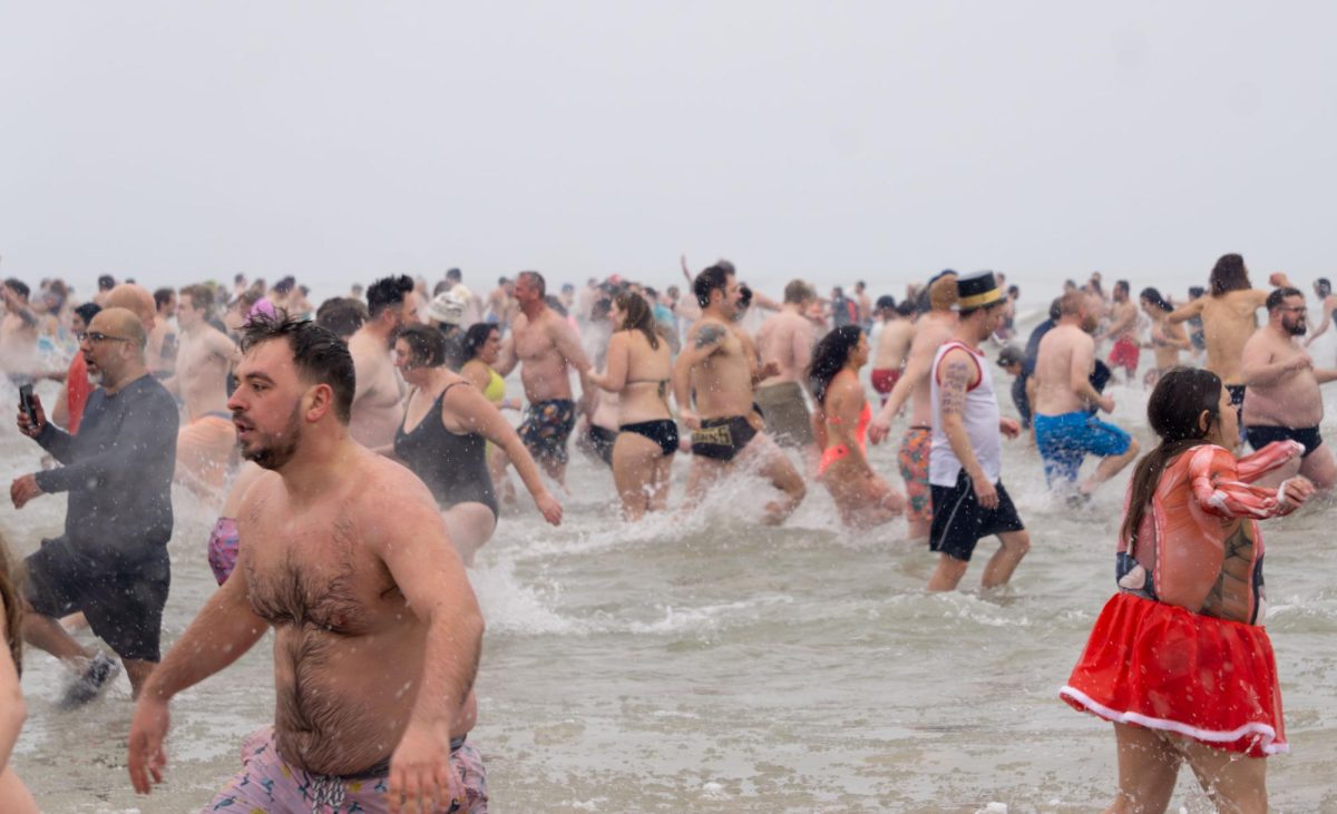 Participants scurry in and out of Lake Michigan during the polar plunge on January 1, 2026 