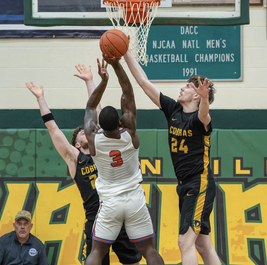 Sophomore point guard Qi'Andre Washington making a shot while two players try to block him. Photo from the NJCAA.
