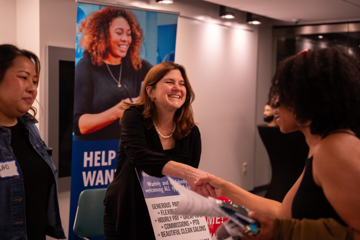An employer greets prospective candidates at the Barber and Cosmetology Employer Marketplace, April 27, 2026.
