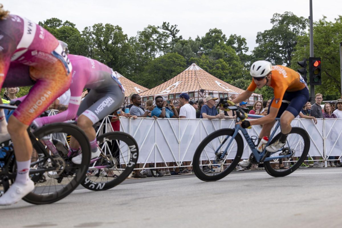 Cyclists speed past a group of spectators 